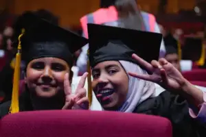 Two ākonga in graduation robes at Children’s University Massey graduation ceremony